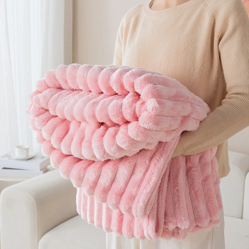 Person holding a pink fluffy blanket in a bright room