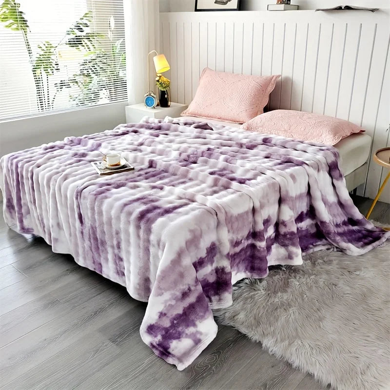 Purple and white tie-dye blanket on a bed in a bedroom setting.