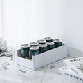 White can holder with Starbucks cans on a marble surface