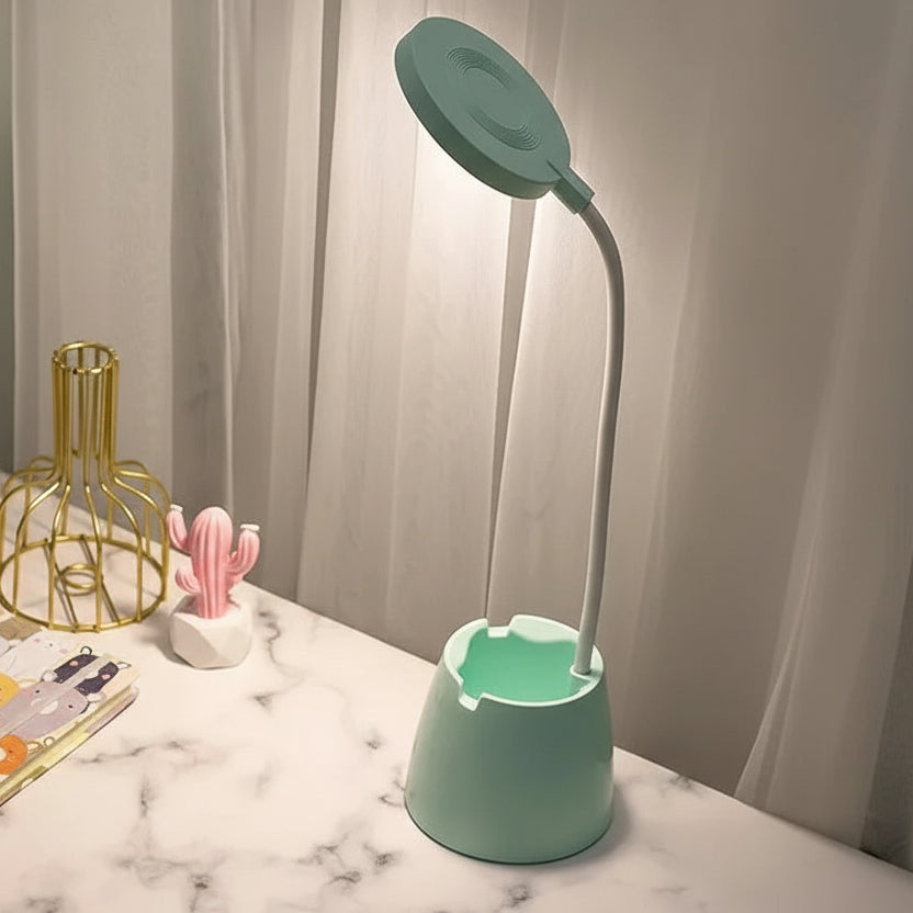 Green LED desk lamp on a marble surface with decorative items.