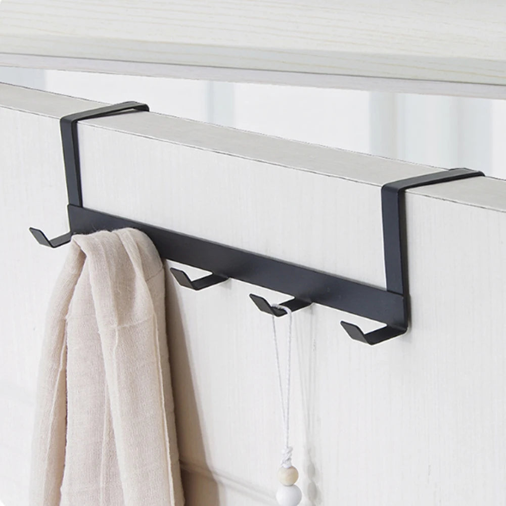 Black over-the-door hook rack used for towels and bathroom accessories