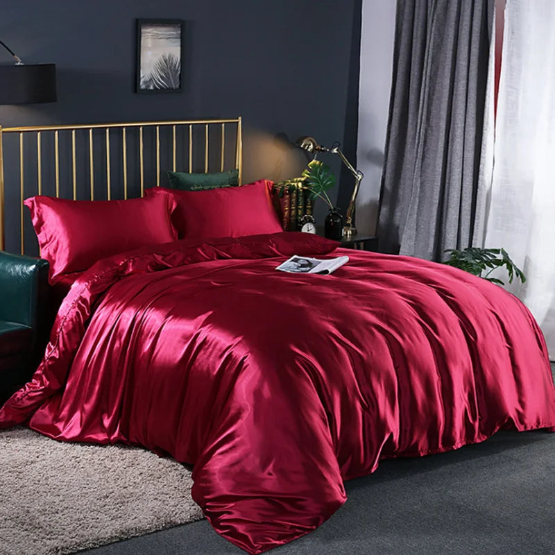 Red satin bedding set on a bed in a bedroom with dark walls and gray curtains.