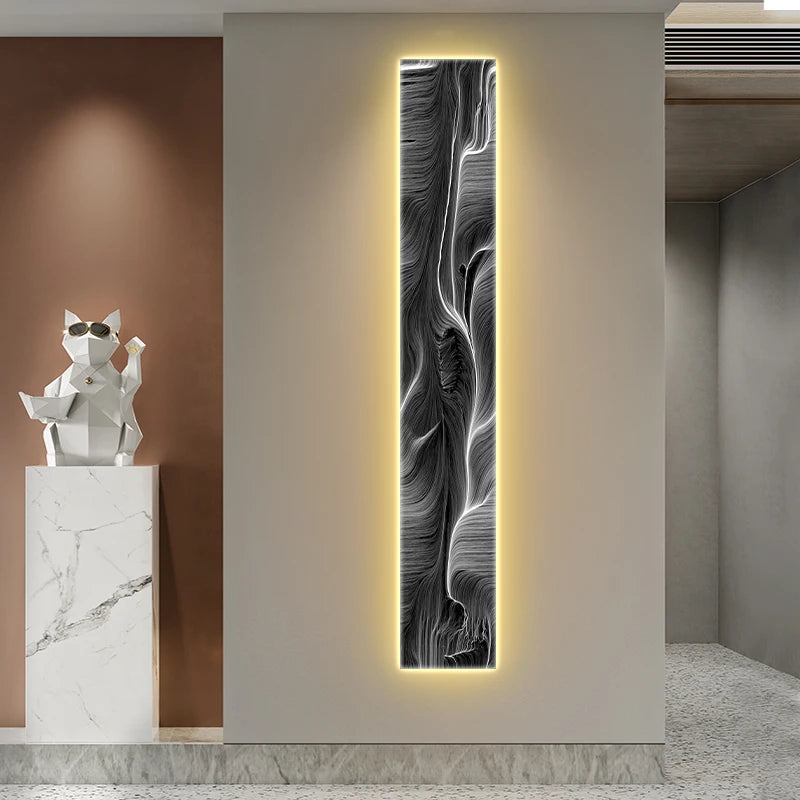 Decorative wall art with abstract design on a light gray wall, next to a white marble sculpture of a cat.