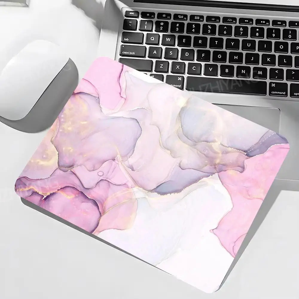Laptop with a colorful abstract mouse pad on a desk