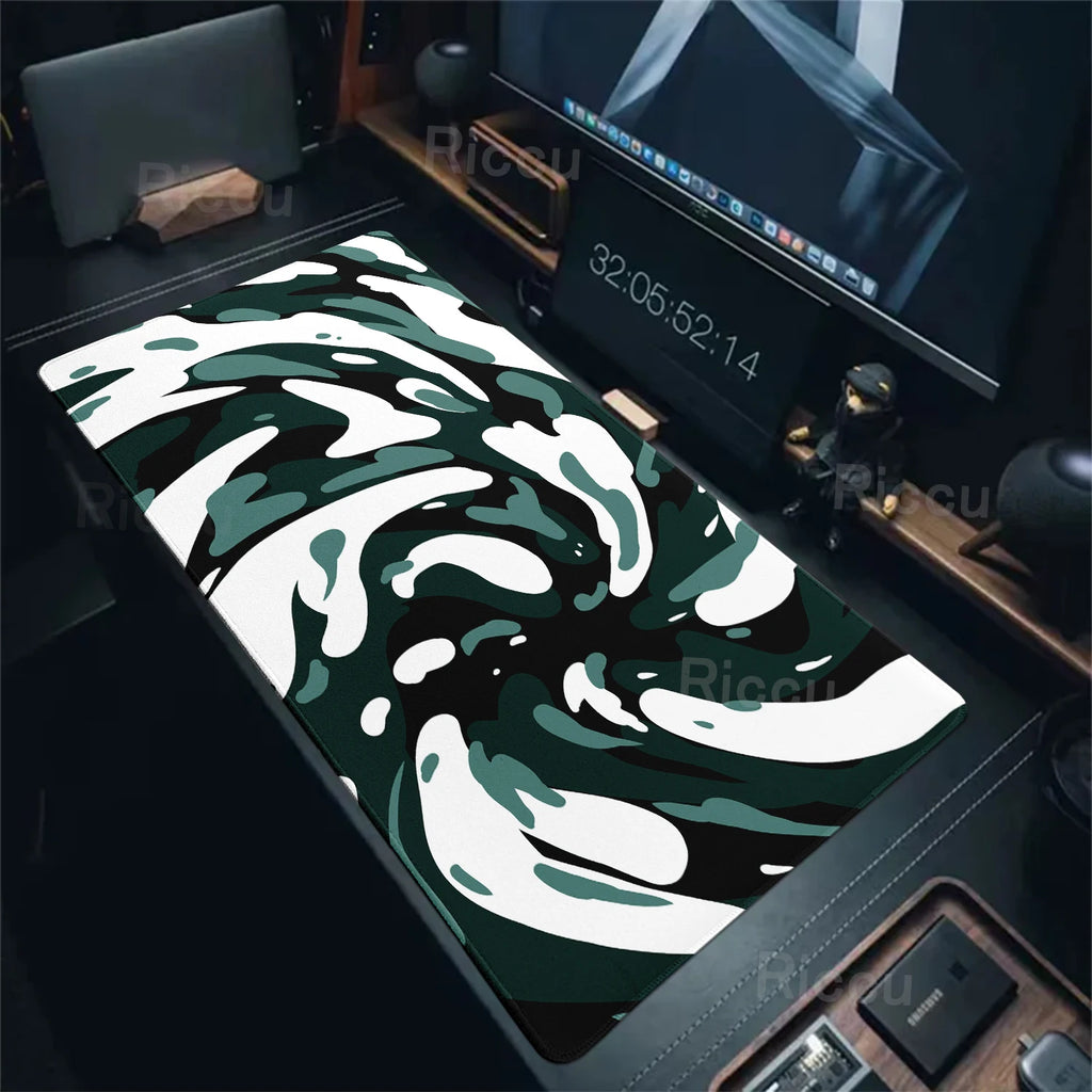 Camouflage-patterned desk mat on a desk with computer equipment.