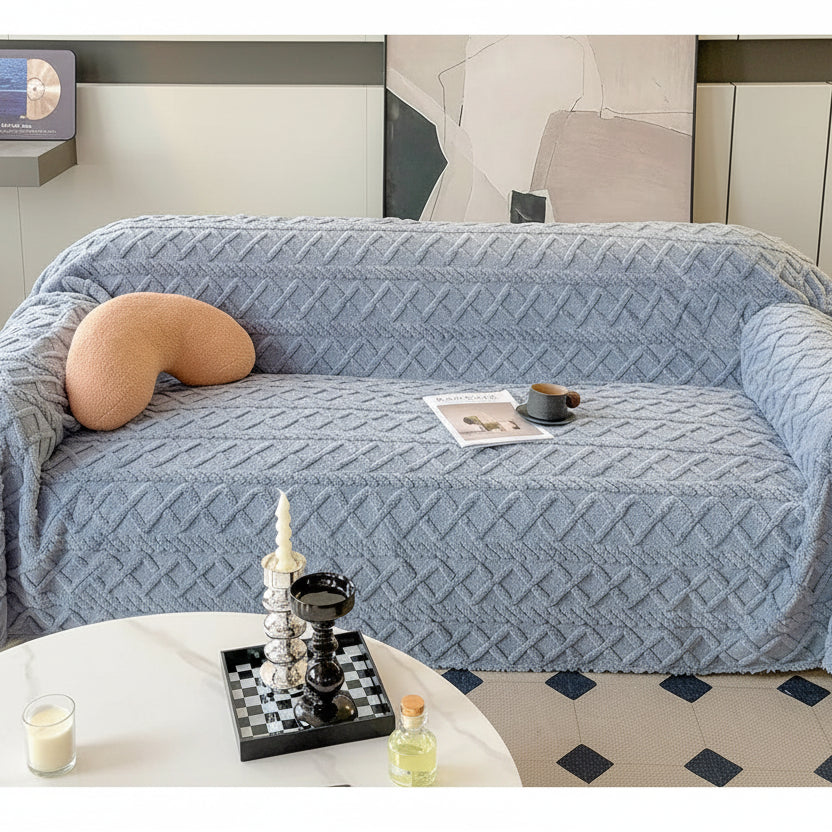 Blue textured sofa cover on a sofa with decorative items in a living room setting.