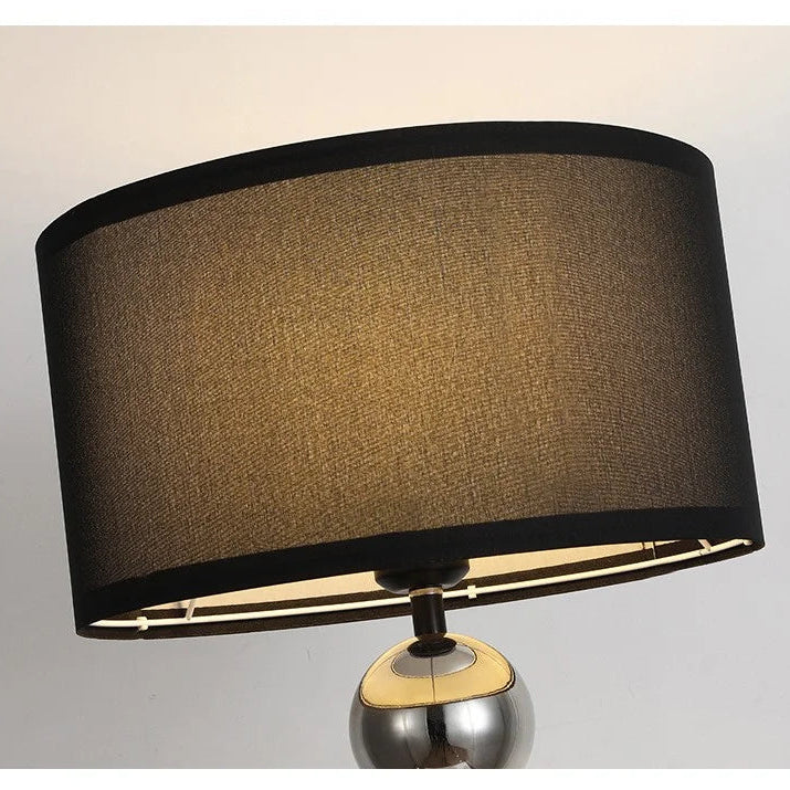 Close-up of a black linen lampshade on a stainless steel floor lamp