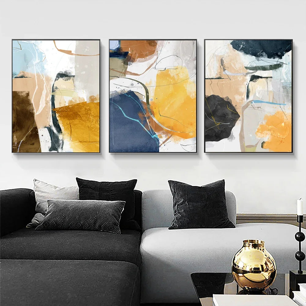 Three abstract art pieces in a living room setting.