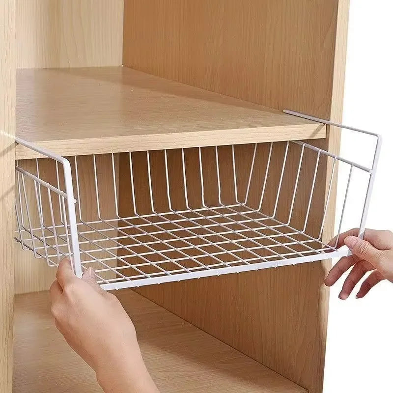 White wire basket being placed into a wooden cabinet.