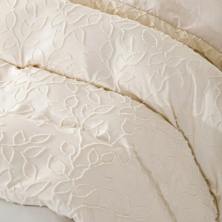 Detailed cream fabric texture showing tatting weave and raised leaf design