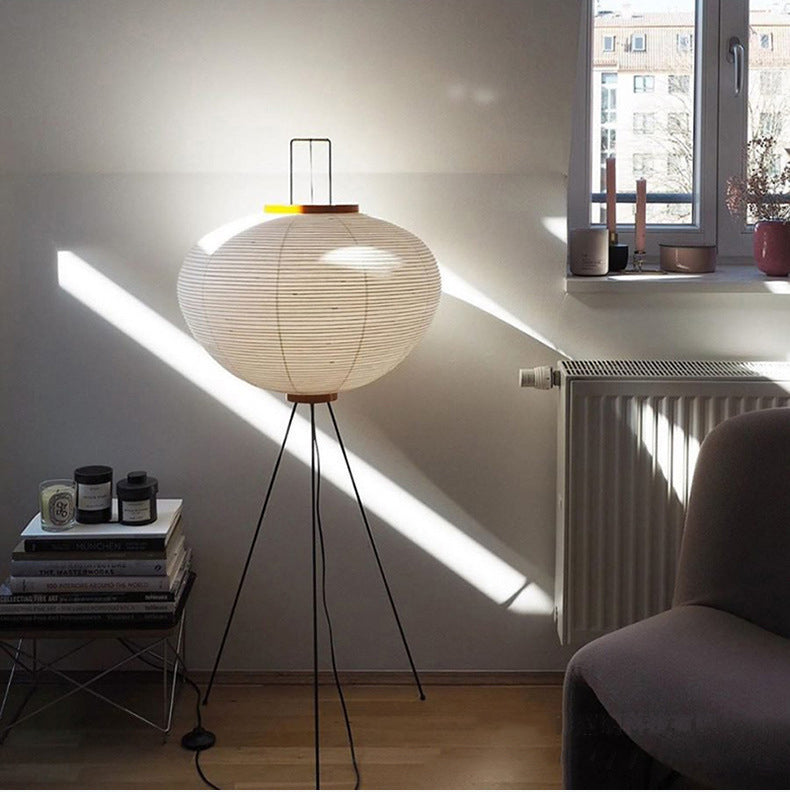 A Japanese modern floor lamp with a white shade in a room with a window and radiator.
