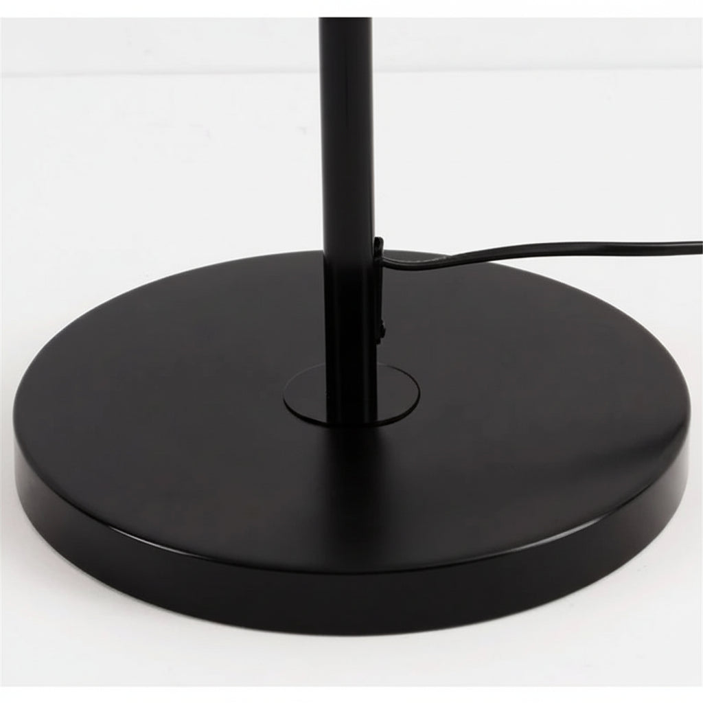 Close-up of the stable circular black metal base and power cord.