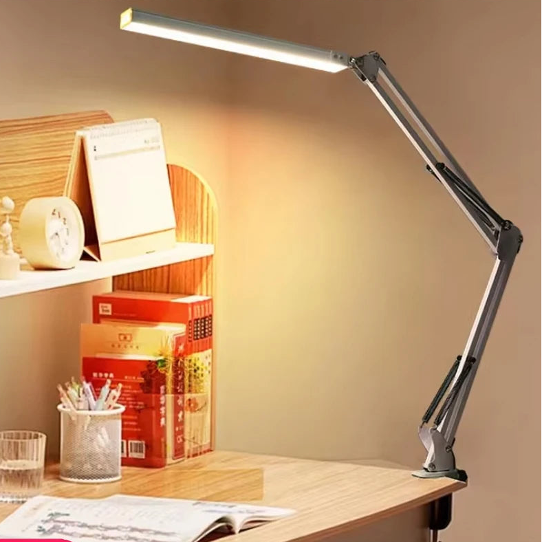 A white adjustable desk lamp on a desk.