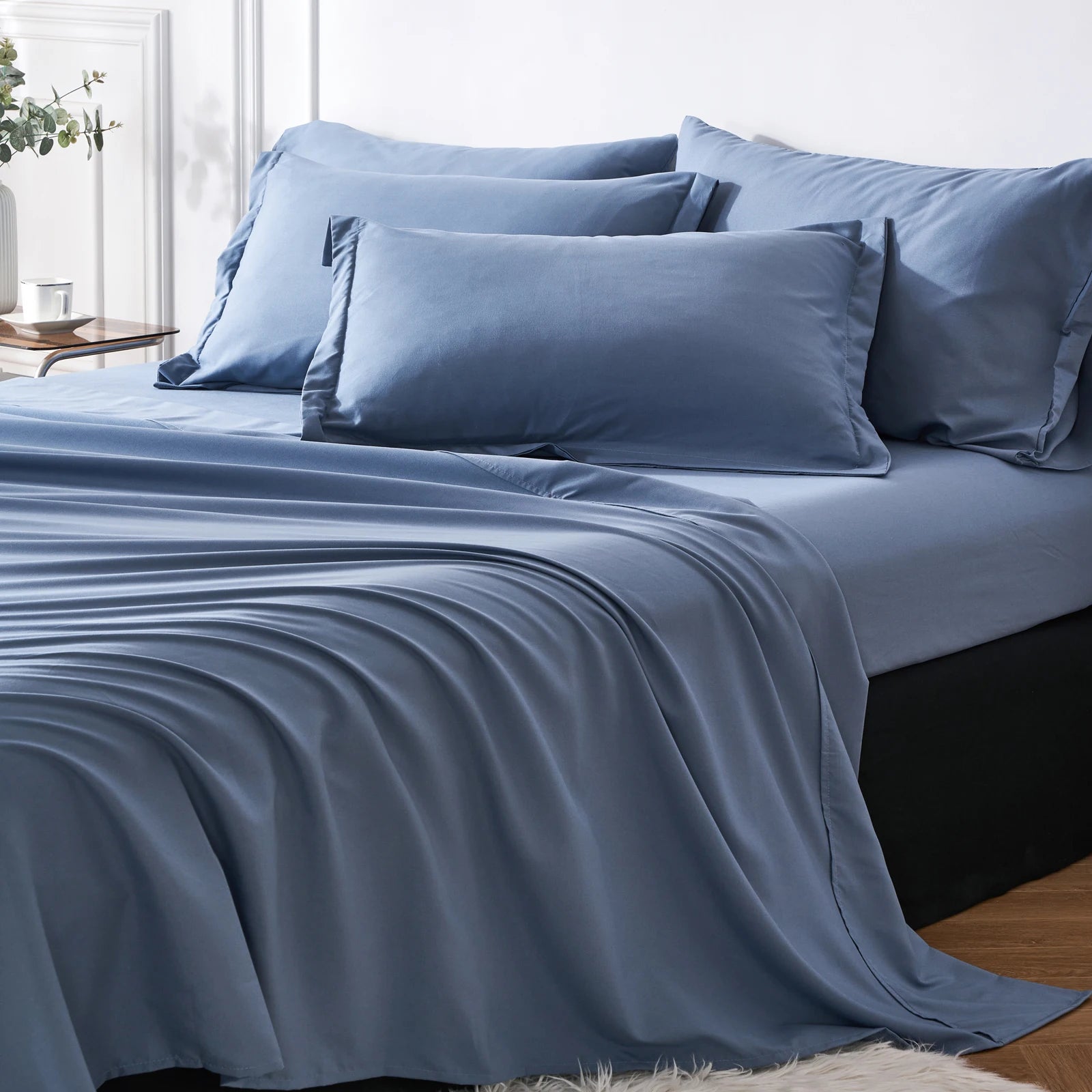 Blue bedding set on a bed with pillows in a bedroom setting.