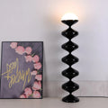 Black sculptural floor lamp with frosted dome shade