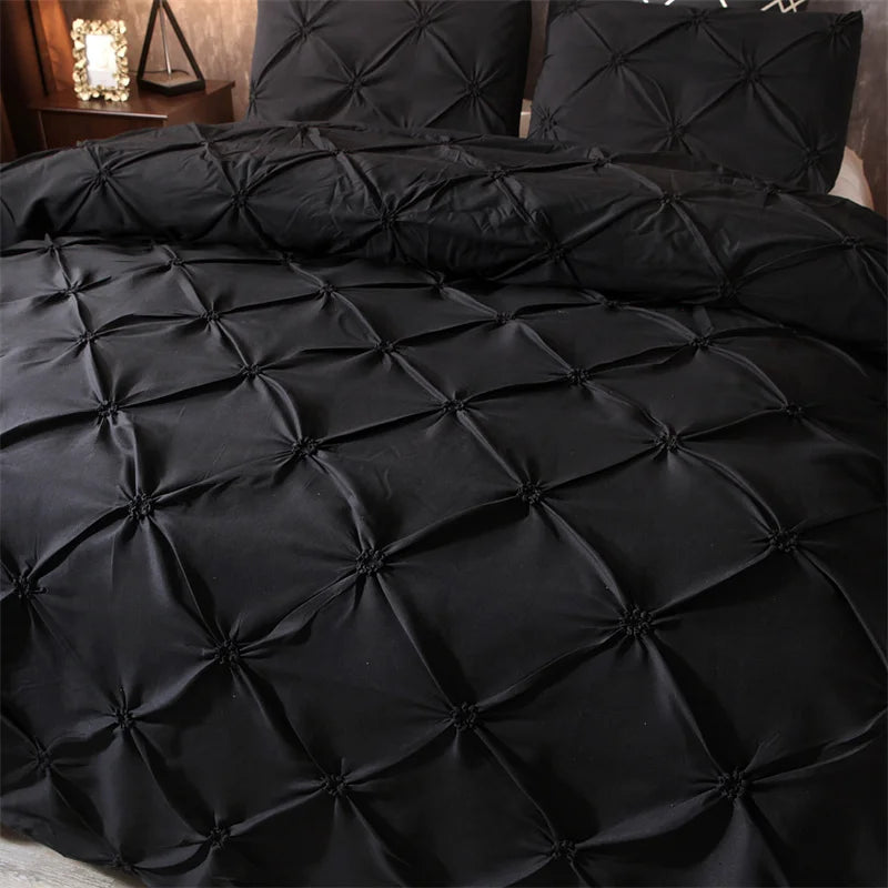 Black pintuck duvet set with matching pillowcases dressed on a double bed in a warm contemporary bedroom