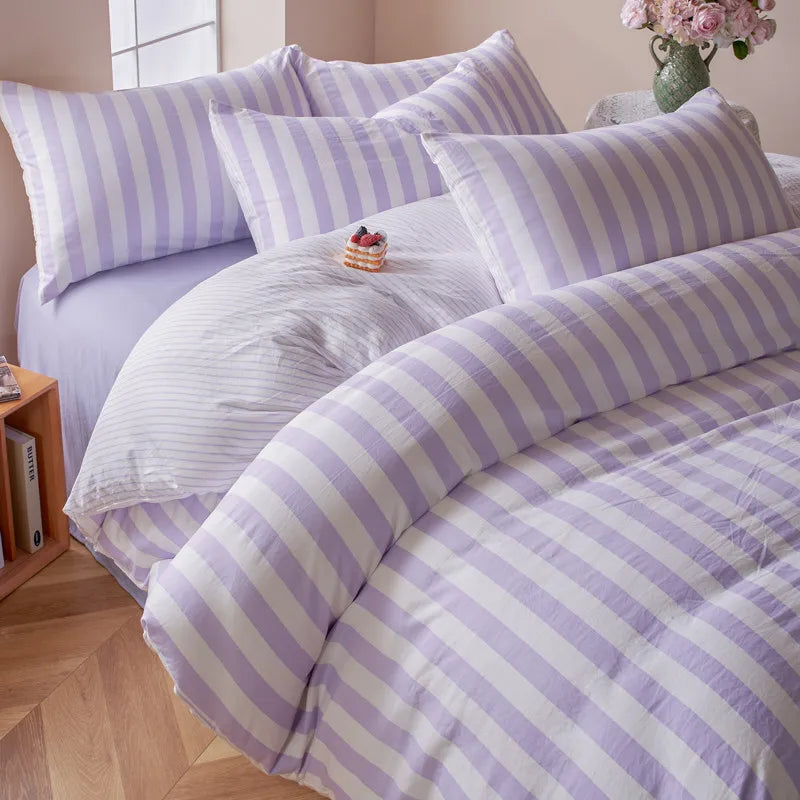 Lavender and white striped Polyester bedding set styled in a bright bedroom