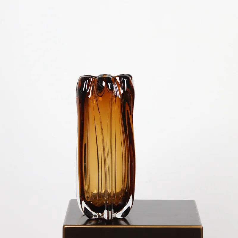 A 25cm high small amber glass vase with a 13cm width and a weighted clear base.