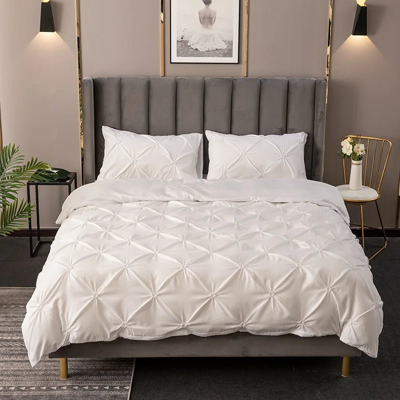 White 3D pinch pleated duvet cover set styled with a grey upholstered headboard.