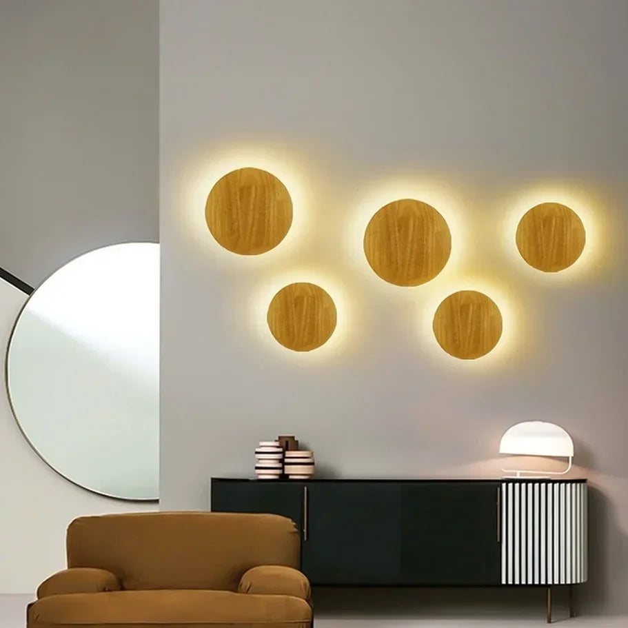 Modern interior design with wooden circular lights on a wall, a brown sofa, and a black console table.