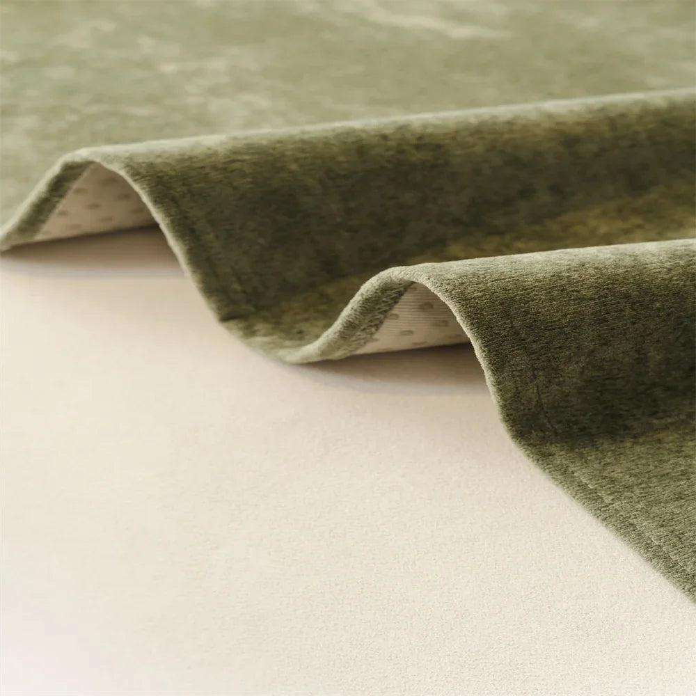 Edge detail showing flexible drape and fabric thickness of the sofa throw