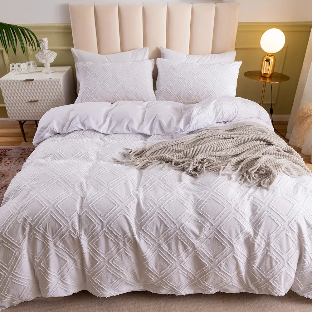 White textured geometric bedding set styled with a throw blanket and upholstered headboard
