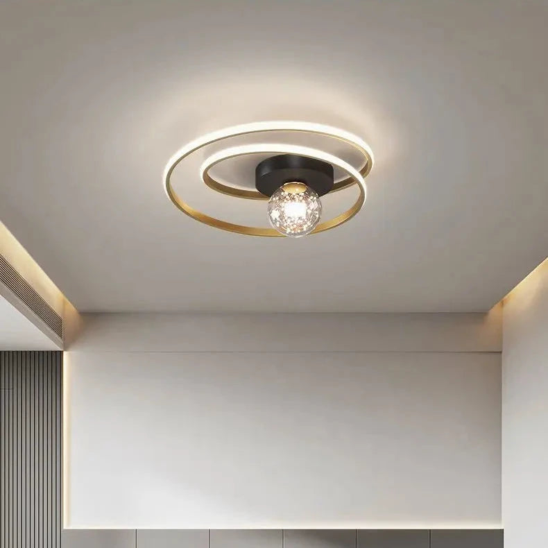 Close-up of black double-spiral LED ceiling light with textured amber glass globe against a white ceiling