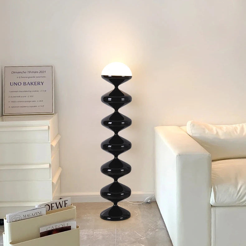 Black sculptural floor lamp with frosted dome shade