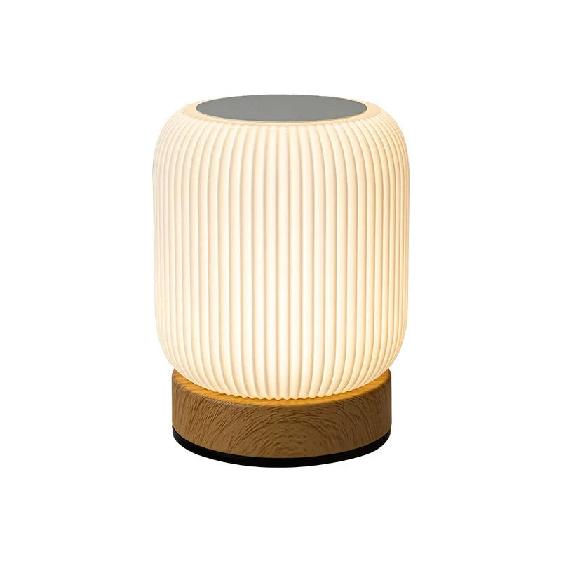 Table lamp with ribbed design and wooden base on a white background