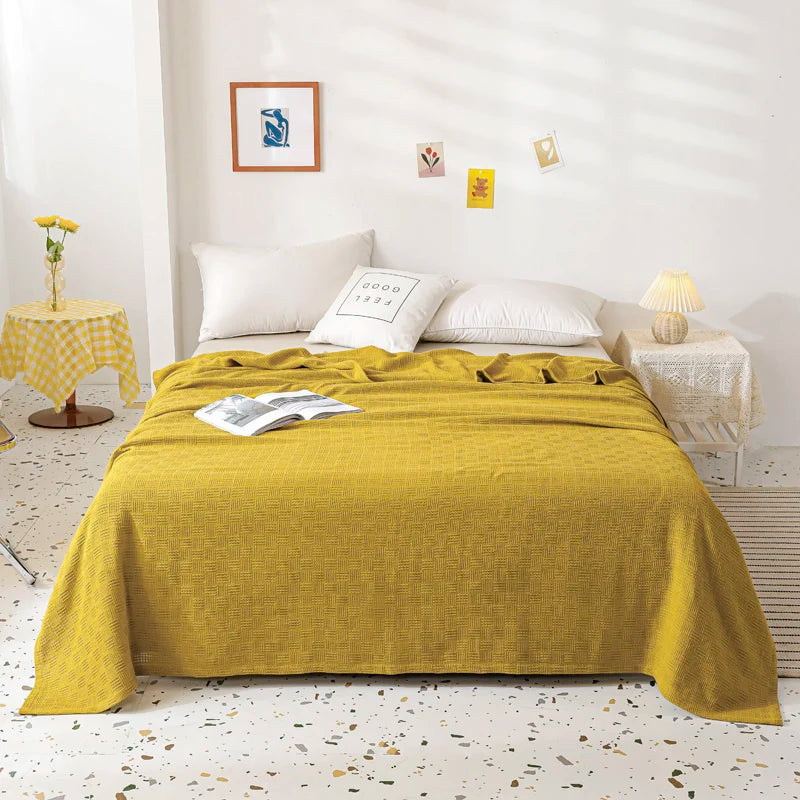 A olive cotton knit throw blanket with textured weave pattern.
