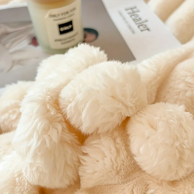 Close-up of a fluffy beige blanket with a blurred background