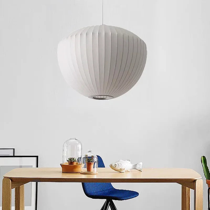 Large white pendant lamp above a wooden dining table in a bright kitchen