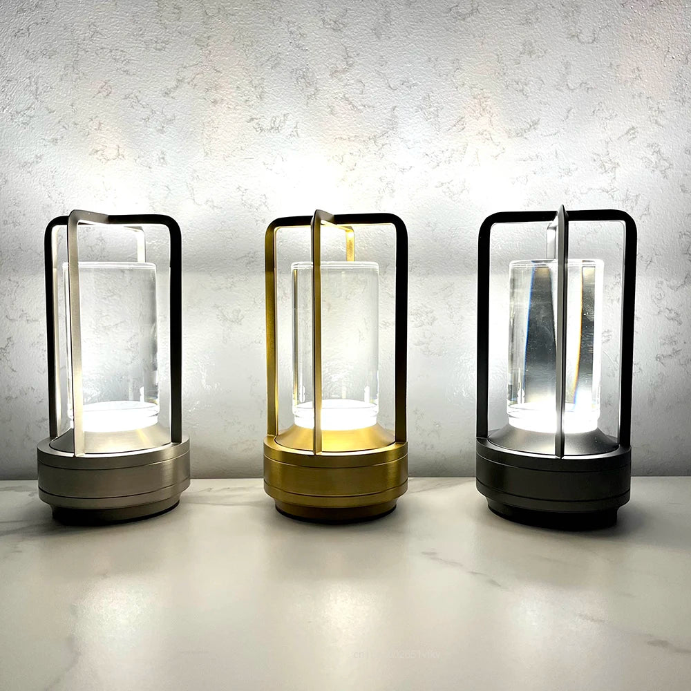 Three cylindrical lamps with different finishes on a light surface.