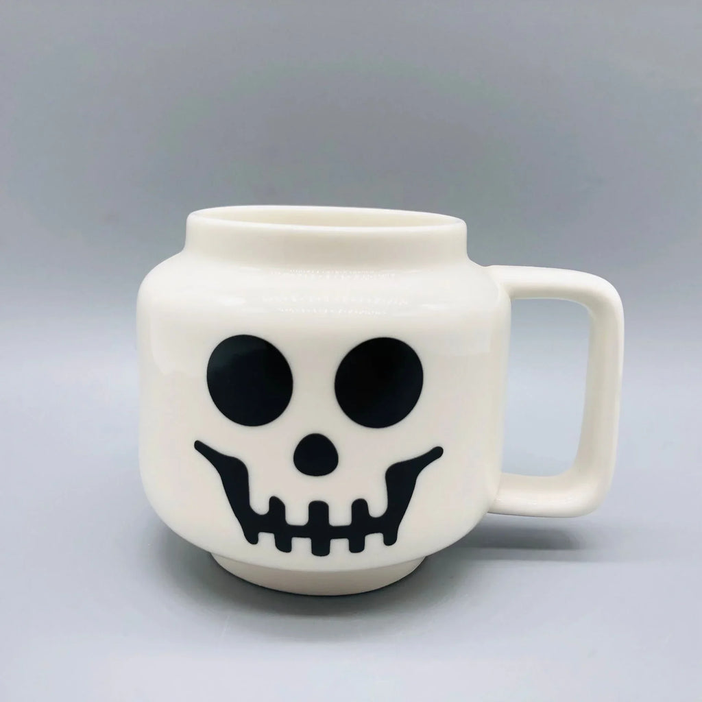 White mug with black skull design on a gray background