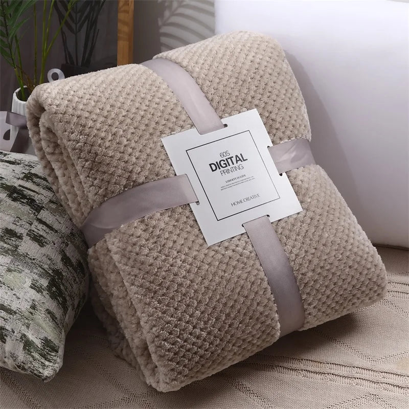 Kharki textured blanket with a label on a couch