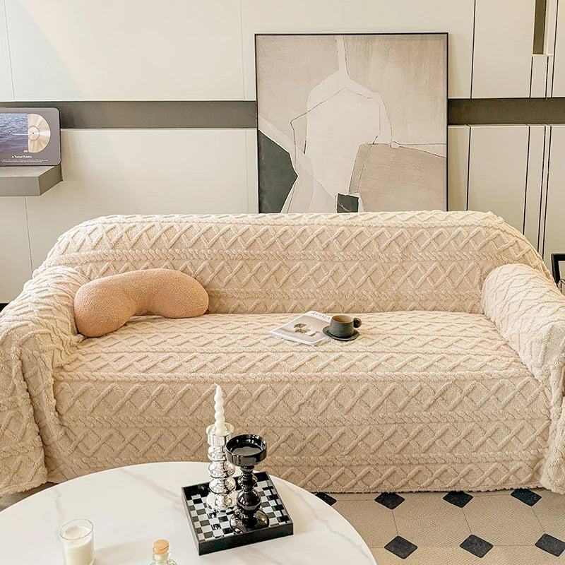 Beige textured sofa with decorative pillows and a coffee table in a living room setting.