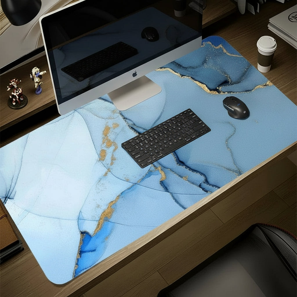 Desk setup with a blue marble-patterned desk pad, computer monitor, keyboard, and mouse.