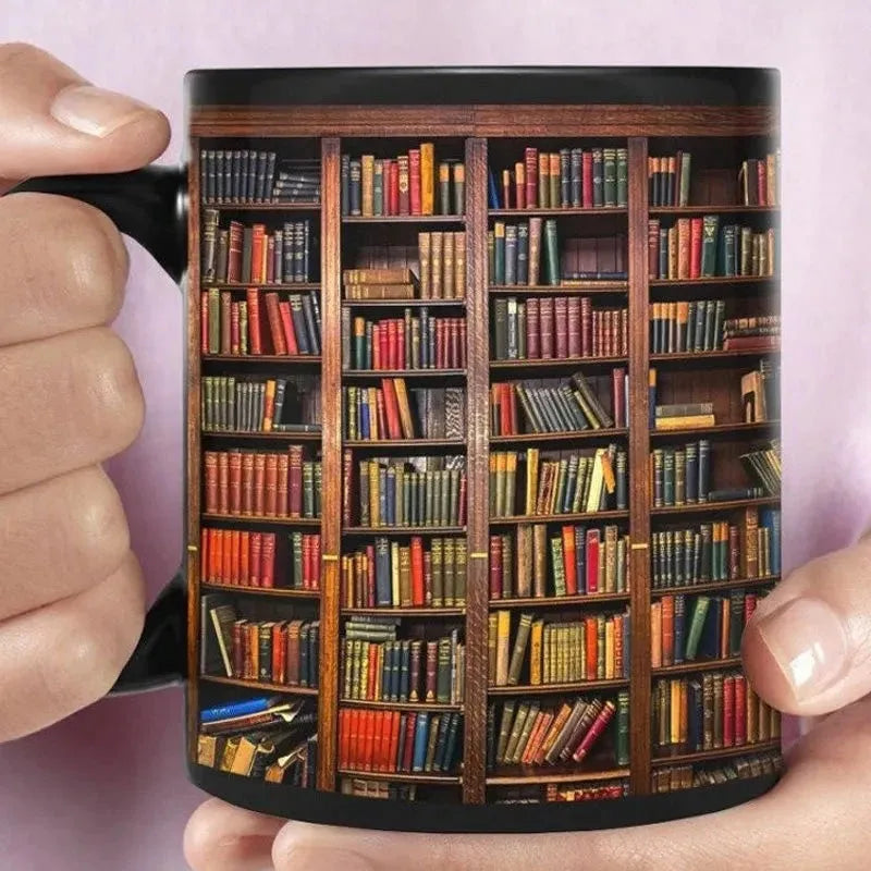 Mug with a design of a bookshelf filled with books held by two hands against a light pink background.