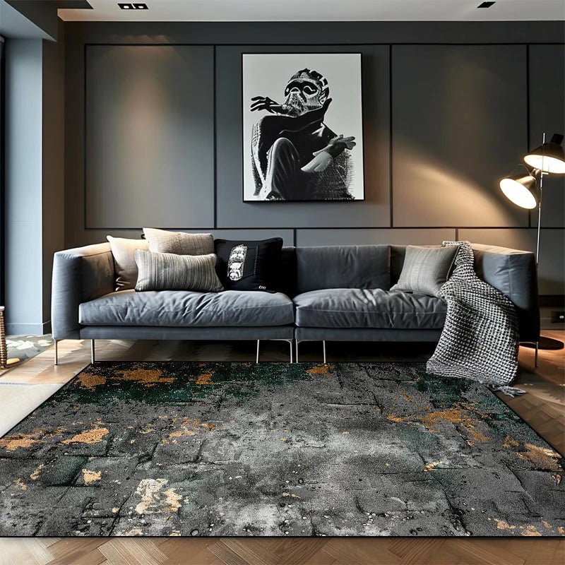 Grey stone-effect abstract area rug with gold and green dust detail in a modern dark living room with a grey sofa