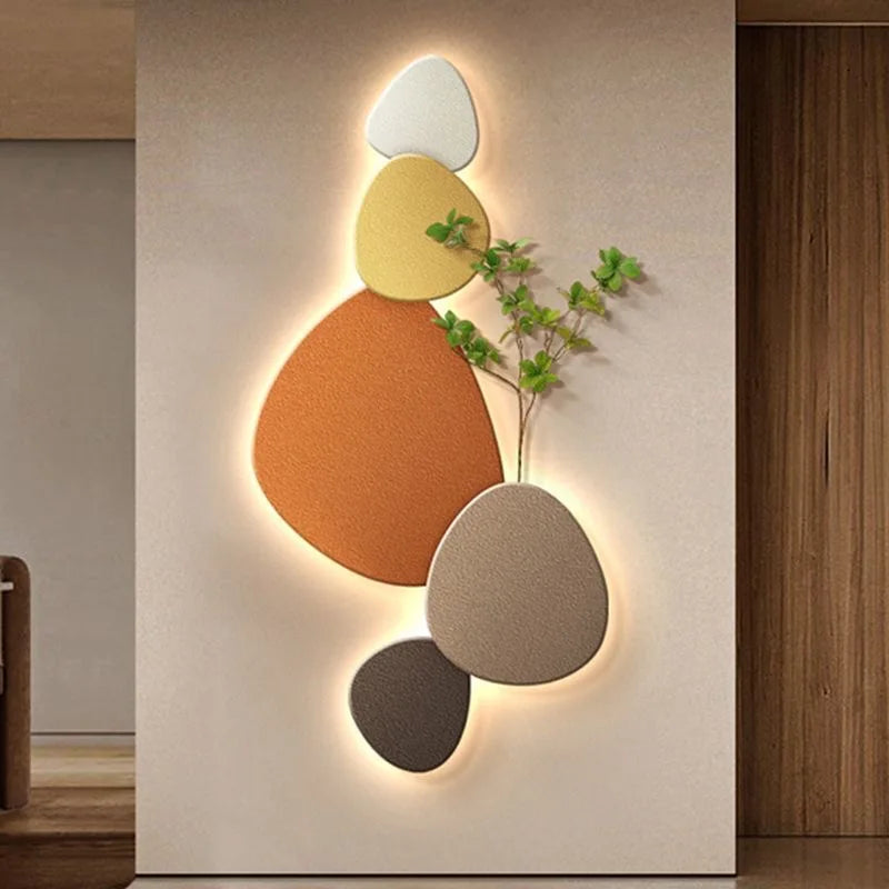 Decorative abstract LED wall light with warm pebble shapes and soft backlighting on a modern wall.