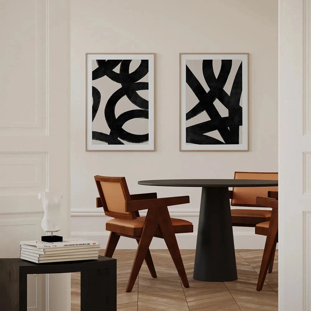 Dining room with abstract art on the wall and a round table with chairs.