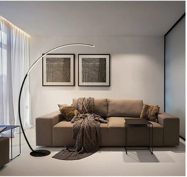 Modern living room with a beige sectional sofa, arc floor lamp, and wall art.