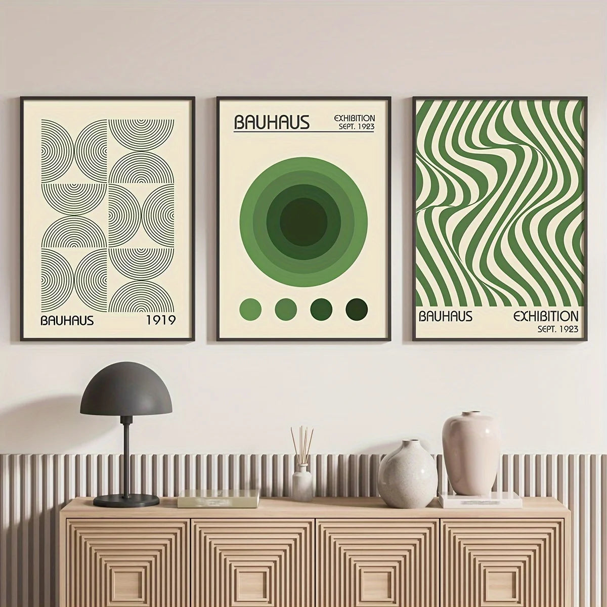Three Bauhaus-themed posters on a wall above a wooden console table.