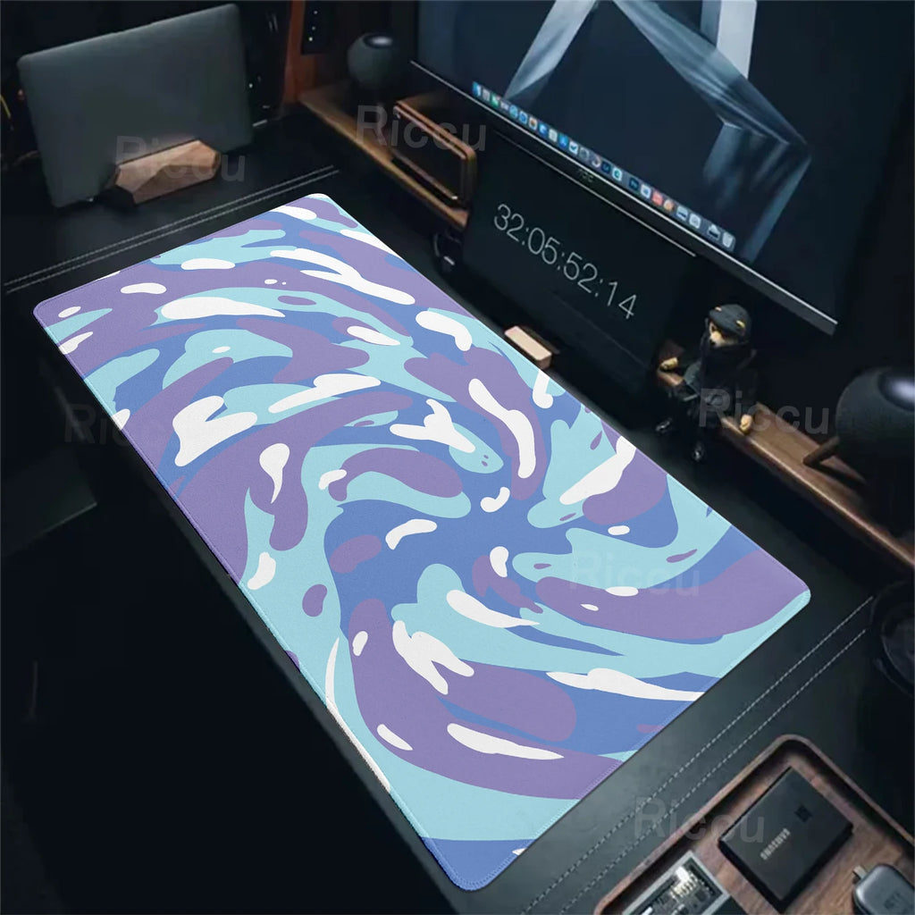 Colorful desk mat on a desk with computer equipment in the background