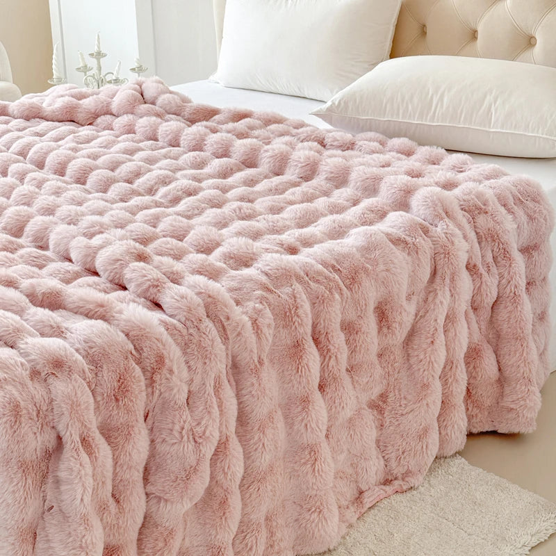 Pink fluffy blanket on a bed in a bedroom setting