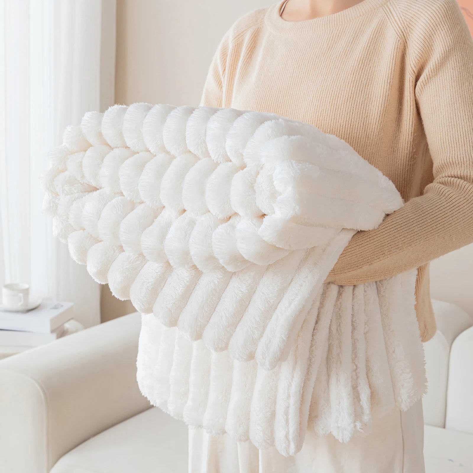 Person holding a large white textured pillow in a cozy indoor setting