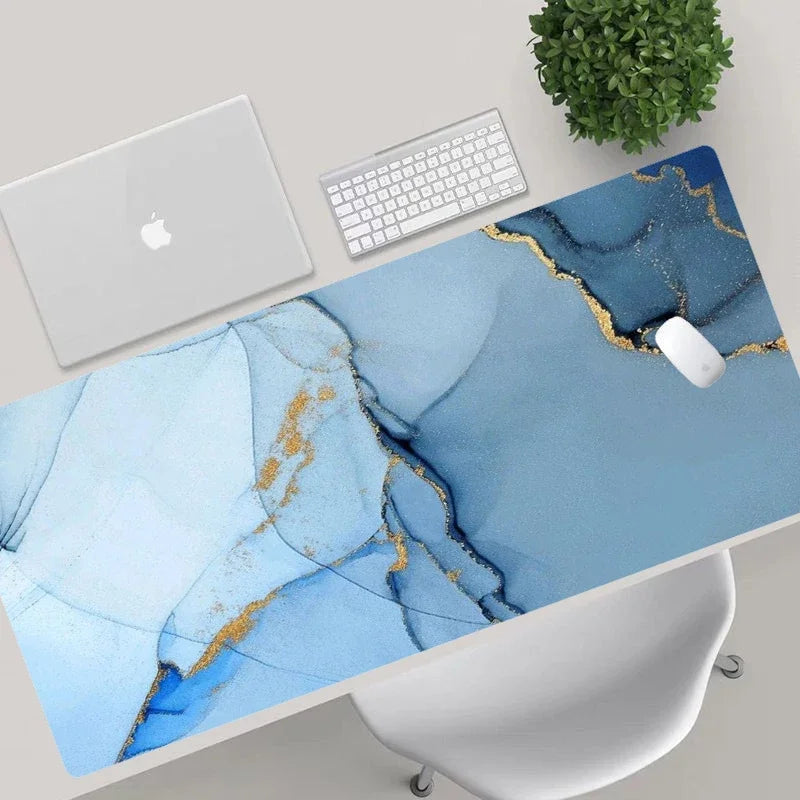 Desk setup with a blue marble desk pad, laptop, keyboard, and mouse.