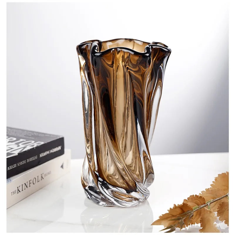 Decorative glass vase with brown and clear swirl pattern on a white surface.