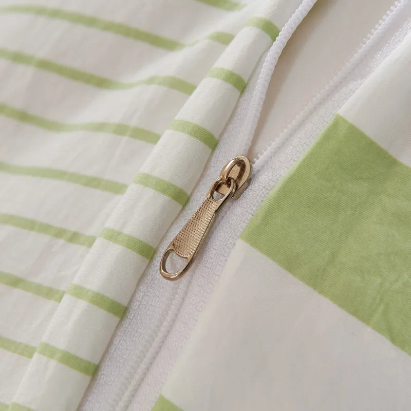Close-up of a green and white striped fabric with a gold zipper.