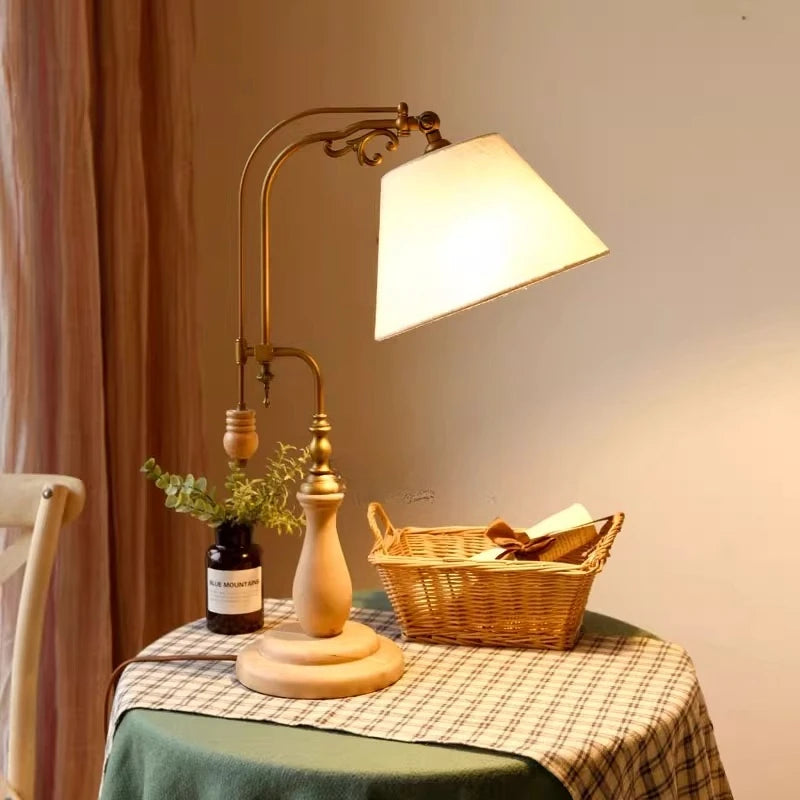 Wood and brass table lamp with ivory fabric shade in warm natural light